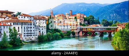 Schöne Stadt Bassano del Grappa, Ansicht mit Fluss Brenta, bunte Häuser und Berge, Venetien, Italien. Stockfoto