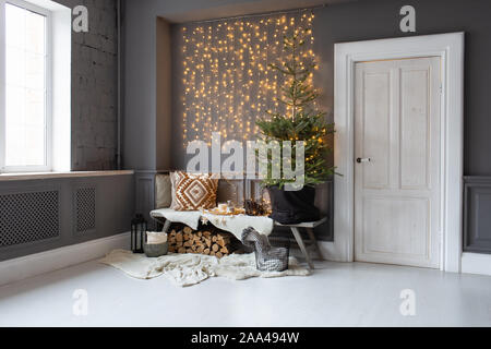 Holzbank stand in der Ecke des Zimmers. Tanne in schwarz Warenkorb stehen auf IT- und Brennholz legt. Stockfoto