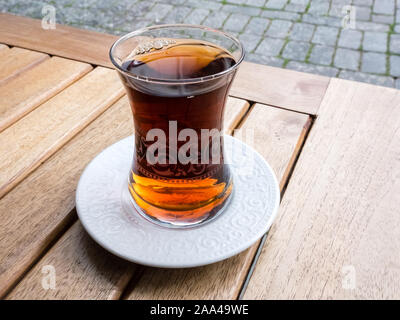 Hot türkischen Tee im traditionellen Glas auf dem Holztisch auf der Straße. Entspannung Konzept Stockfoto