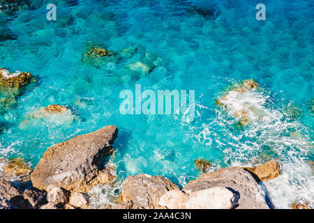 Blau smaragdgrünen Meer Wasser mit großen Steinen am Strand. Felsigen Ufer transparent Türkis unten Malta. Stockfoto