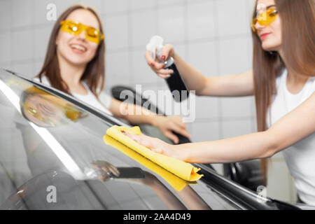schöne Frau waschen Auto Windschutzscheibe, Stock Bild