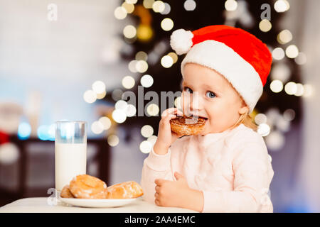 Süße kleine Mädchen genießen Milch mit Cookies Stockfoto