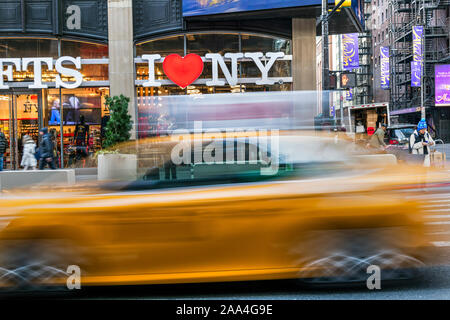 Ich liebe New York Geschenk Schild und unscharfes gelbe Taxi vorbei, Times Square, Manhattan, New York, USA Stockfoto