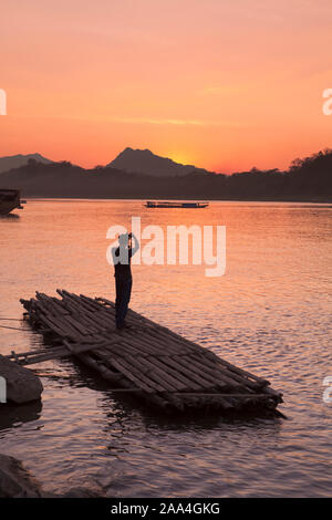 Tourist, der ein Bild der Sonnenuntergang über dem Mekong, Luang Prabang, Laos Stockfoto