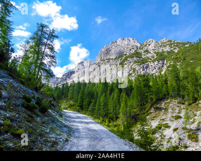 Eine kleine und geschotterten Straße in der Bergwelt der Lienzer Dolomiten, Österreich. Die Berge sind teilweise mit grünen Büschen überwachsen. Gefährliche Berg Stockfoto