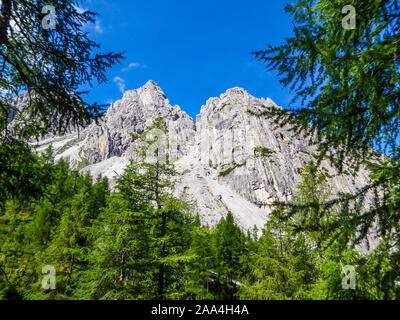 Ein Blick auf die massiven, scharfe Stony Mountain Range der Lienzer Dolomiten, Österreich. Die Berge sind teilweise mit grünen Büschen überwachsen. Gefährlich Stockfoto