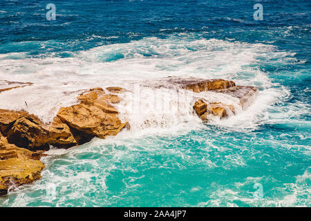 Blau smaragdgrünen Meer Wasser mit großen Steinen am Strand. Felsigen Ufer transparent Türkis unten Malta. Stockfoto