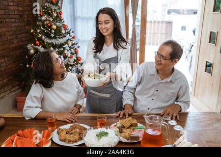 Frau mit traditionellen Speisen für die ganze Familie in der Weihnachtszeit Stockfoto