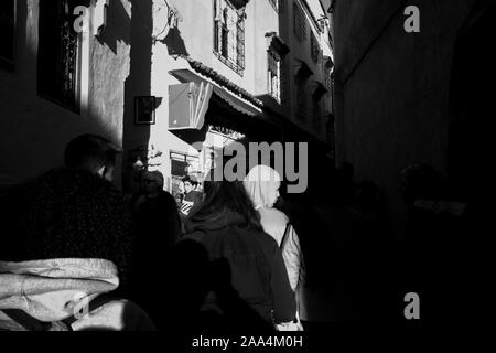 Eine Frau mit einem Schleier aus einer Menge von Menschen in den Straßen von Chefchauen die blaue Perle in den Bergen von Marokko. Stockfoto