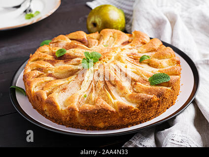 Hausgemachte Torte mit Birnen und Mandeln Mehl auf dunklem Hintergrund. Stockfoto