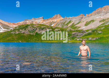 Junge happy fit Mann, Schwimmen im kalten Wasser bunt Eis See auf dem berühmten Trail in Silverton, Colorado in San Juan Berge im Sommer Stockfoto