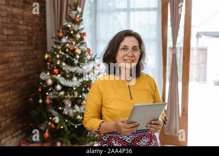 Asiatische reife Frau mit Tablet-PC Stockfoto