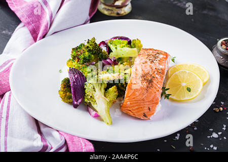 Gebackenes Lachsfilet mit Brokkoli, rote Zwiebel und Zitrone. Stockfoto