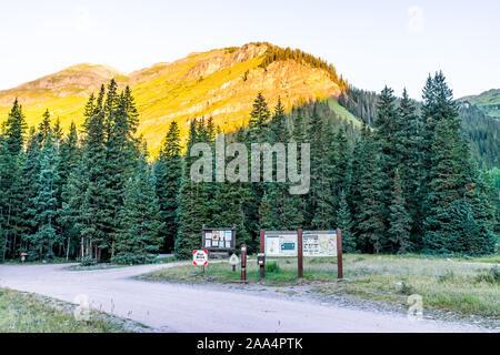 Silverton, USA - 20. August 2019: Ice Lake Trail in Colorado im Sommer morgen von mineralischen Campingplatz mit eingangsschild und sunrise Licht von Pine Tree Stockfoto