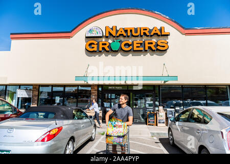 Durango, USA - 22. August 2019: Mann beenden Einkaufen mit Warenkorb und Taschen mit Vorzeichen vor dem Eingang zu den natürlichen Lebensmittelgeschäft, Supermarkt, Parkplatz Stockfoto