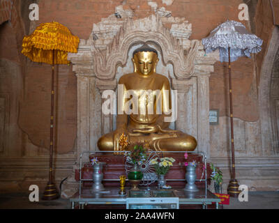 Eine von vier vergoldeten Buddha Statuen mit Sonnenschirmen gefunden in der Htilominlo Tempel von Bagan (ehemals Heidnischen), Myanmar (Birma) Stockfoto