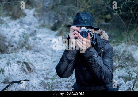 Bärtiger Mann verfangen snowy Fotos mit Hut auf verschneiten Hintergrund Stockfoto