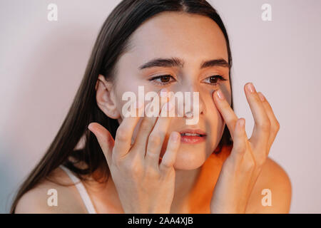 Frau Augencreme anwenden Stockfoto