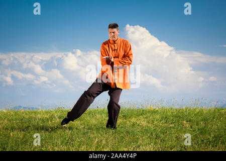 Ein Mann, der unter freiem Himmel Qi-Gong-Uebungen durchfuehrt Stockfoto