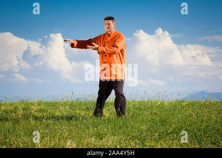 Ein Mann, der unter freiem Himmel Qi-Gong-Uebungen durchfuehrt Stockfoto