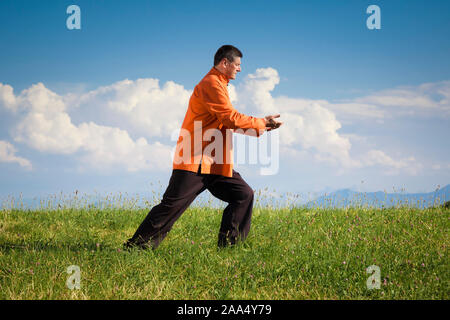 Ein Mann, der unter freiem Himmel Qi-Gong-Uebungen durchfuehrt Stockfoto