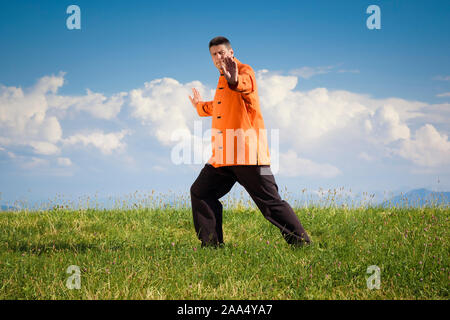 Ein Mann, der unter freiem Himmel Qi-Gong-Uebungen durchfuehrt Stockfoto