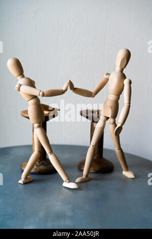 Zwei Holz- menschliche Figuren auf dem Tisch zu stehen Hände schütteln Stockfoto