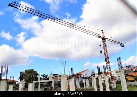 Baukräne Bau der Häuser Kran und Gebäude Baustelle gegen den blauen Himmel mit weißen Wolken Stockfoto