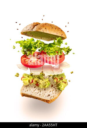 Darstellung der Einzelteile und fliegende vegetarisches Sandwich mit Guacamole und Tofu Käse auf Weiß Stockfoto