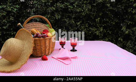 Rosa serviette Picknickkorb und zwei Gläser Wein. Zwei Gläser und eine Flasche Wein. Picknick im Park. Gutes Wochenende. Feder Stockfoto