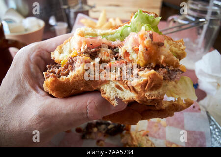 Mann essen größere Burger und Pommes frites in einer lokalen American Diner in Florida, USA Stockfoto
