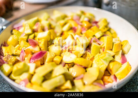 Kochen Braten mit hausgemachten gehackte gelbe Sommer zucchini Kürbis Gemüse gefüllt pan Makro Nahaufnahme in der Küche am Herd mit roten Zwiebeln Stockfoto