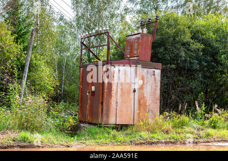 Alte spannung strom Umspannwerk am Dorf im Sommer Stockfoto