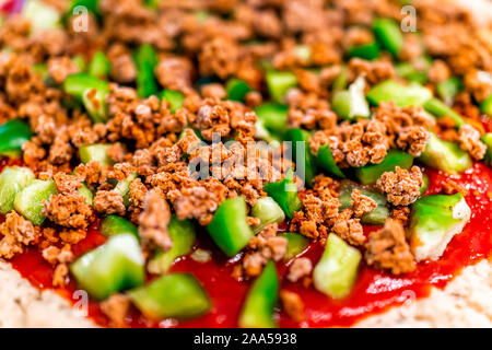 Makro Nahaufnahme von hausgemachten ungekocht Pizza mit Tomatensauce und Toppings grüne Paprika gehackte mit Masse vegan Rindfleisch bröckelt Stockfoto