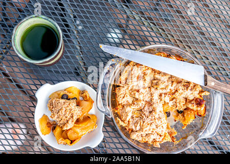 Außerhalb der Tabelle und einen Top-down-Sicht der ganzen Apfel Obst Torte gebacken vegane Nachspeise goldene Kruste mit Matcha grüner Tee in Tasse und Teller servieren in Scheiben geschnitten Stockfoto