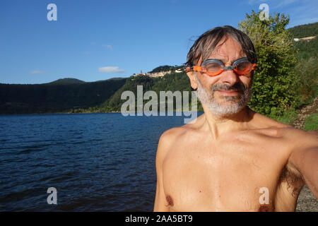 Lächelnd älterer Schwimmer in Nemi See, Italien Stockfoto