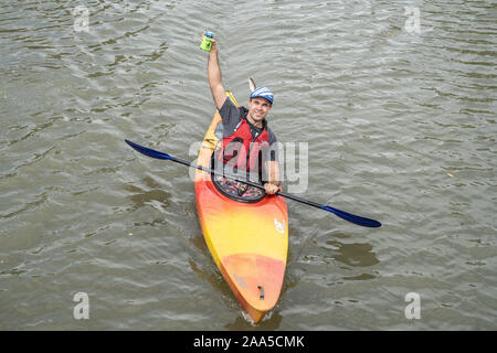 September 1, 2019, Ithaca New York, USA: Mann paddeln Kajak in cannal, halten eine fertige Getränk in der Hand. Stockfoto