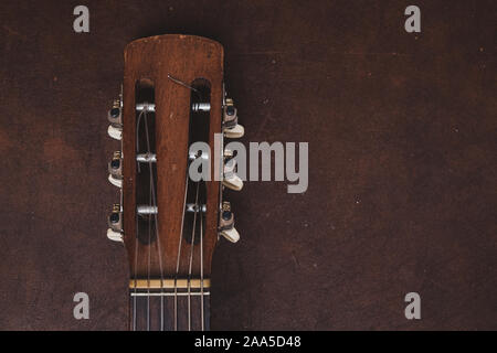 Hohe Betrachtungswinkel vintage Altmodische akustische Gitarre Kopf und Stimmwirbel Detail auf hölzernen Hintergrund Stockfoto