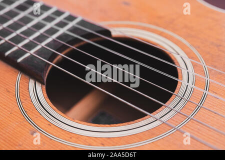 Makro Detail Musik Konzept Akustik Gitarre Akkorde Körper und Loch vintage zerkratzt Resonanzboden aus Holz Stockfoto