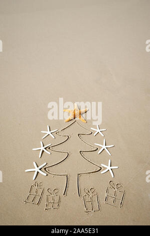Umweltfreundliche Weihnachtsbaum mit Seestern tree Topper und einfache präsentiert am Strand mit weichem Sand Kopie Raum gezeichnet eingerichtet Stockfoto