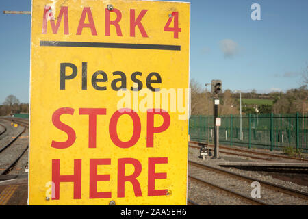 Bitte halten Sie hier gelbes Schild am Bahnhof oder Bahnhof Plattform in Irland als Warnung nicht den Track Linien zu kreuzen. Stockfoto