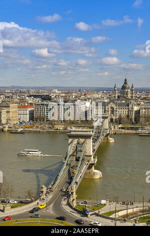 BUDAPEST, Ungarn - März 2019: Die Kettenbrücke, die die Donau in der Mitte von Budapest, überquert. Ein touristenboot vorbei Stockfoto