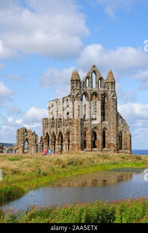 Besucher verlassen Whitby Abbey. Reflexion in den Teich. Porträt. Stockfoto