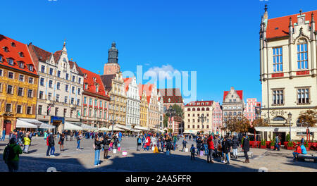 Touristen am mittelalterlichen Breslau Marktplatz mit seinen bunten Häusern und der Hl. Elisabeth Kirchturm im Hintergrund. Polen Stockfoto