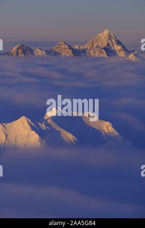 Winter Luftbild der Chugach Mountains schwebt über den Wolken bei Sonnenuntergang, Alaska Stockfoto