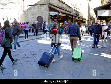 11 November 2019 - Florenz, Italien: Touristen die die berühmte Brücke Ponte Vecchio mit ihren Trolleys in Florenz, Italien. Stockfoto