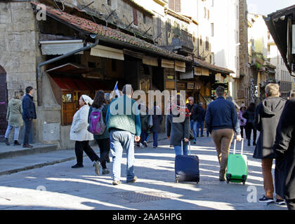 11 November 2019 - Florenz, Italien: Touristen die die berühmte Brücke Ponte Vecchio mit ihren Trolleys in Florenz, Italien. Stockfoto