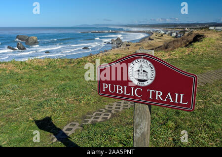 Ein gepflasterter Weg führt entlang der Klippen in Bandon, Oregon, mit einem Schild, auf dem "Öffentlichen Trail' Stockfoto