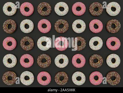 Rosa Donuts, Schokolade, weiße Schokolade auf dunklem Hintergrund. Stockfoto