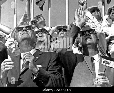 Inmitten einer Masse von anderen Zuschauern, US-Vizepräsident Spiro T. Agnew (rechts) und der ehemalige US-Präsident Lyndon B. Johnson watch die Saturn V Fahrzeug brüllen himmelan die Apollo 11 bemannte Raumfahrzeuge in den weiten Regionen des Weltraums. Stockfoto